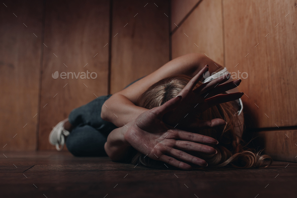 Selective focus of victim with obscure face lying on floor