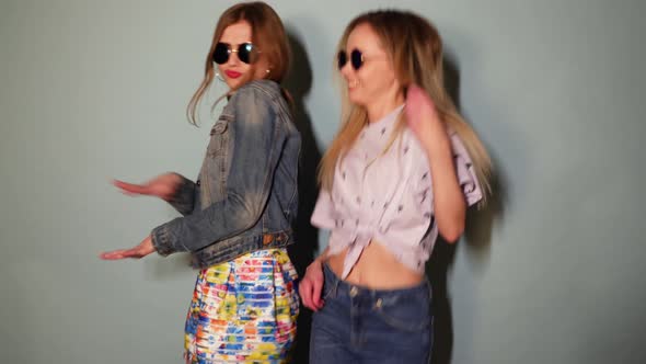 Two Carefree Young Girls Going Crazy. Women in hipster summer clothes having fun and dancing alt