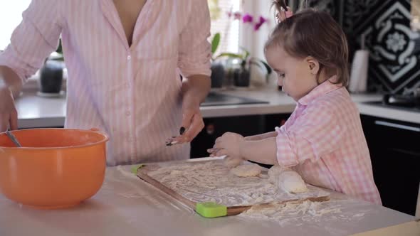 Mother Cooking Together with Little Daughter at Kitchen