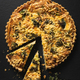 Top down view of a delicious broccoli quiche on black slate background on wooden table - PhotoDune Item for Sale