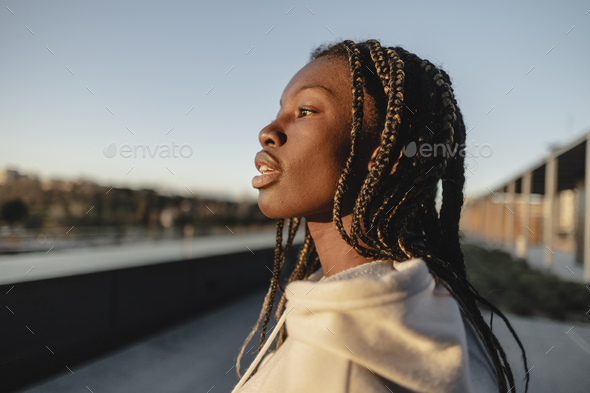 African young woman with dreadlocks, in profile contemplating the city. - Stock Photo - Images