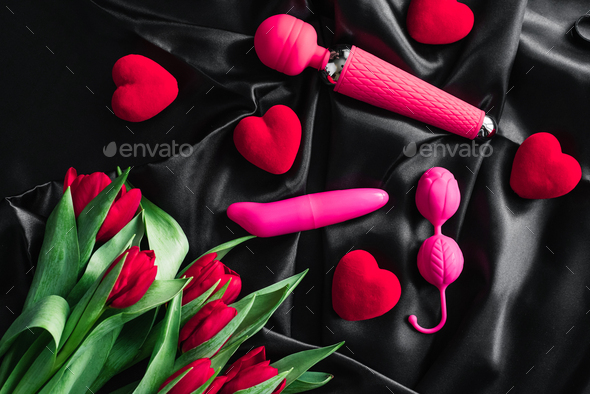 Various sex toys set on a black background. Advertising a sex shop. Spring. Tulips