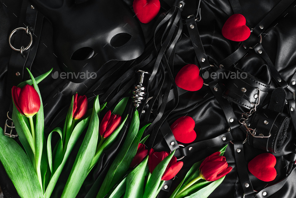 Explore The World Of Kinky Play Top View Of Bdsm Leather Kit Against Of A Black Silk Tulips 7862