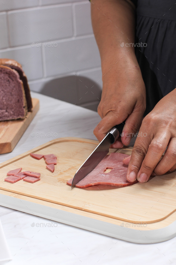 Asian Chef Female Hand Sliced Smoked Beef into Small Pieces. Cooking Process in the Kitchen