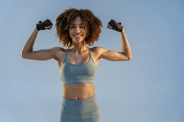 Sporty woman flexing muscles with energy to show off her biceps