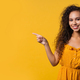 Smiling woman presenting something isolated on yellow background. copy space - PhotoDune Item for Sale