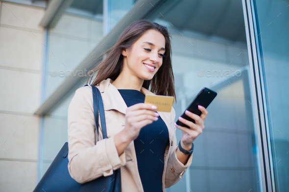 Woman Using Gold Credit card and Cellphone For Paying.