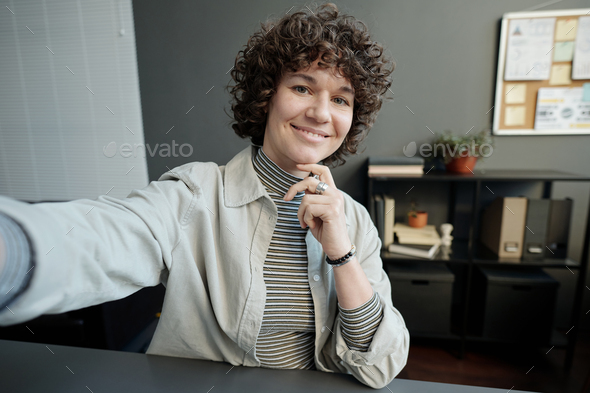 Young smiling female white collar worker looking at camera