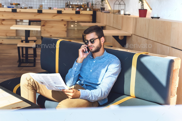 A girl wearing sunglasses is reading a newspaper · Free Stock Photo