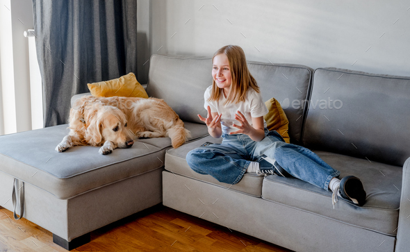 Preteen girl with golden retriever at home