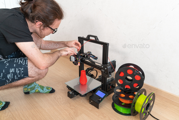 Modern 3D printer and multi-colored filament spools - Stock Photo - Images