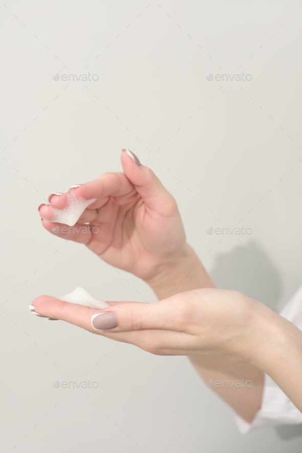 female hands with foam mousse, moisturizer, after tan treatment, woman holding foam cleanser