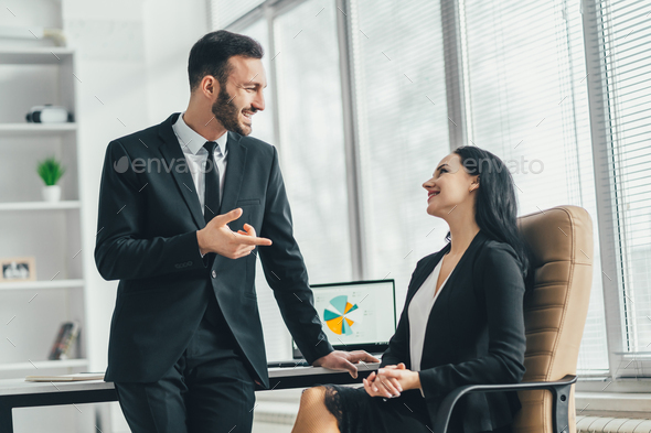 The business man and a woman talking near the office table Stock Photo ...