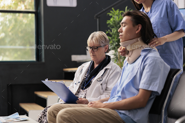 Assistant and physician helping asian patient to take off neck collar while trying to recovery after