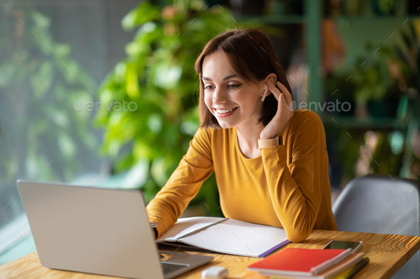 Cheerful young woman attending online business meeting, cafe interior - Stock Photo - Images