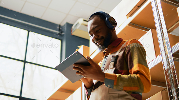 African american man listening to music using tablet - Stock Photo - Images