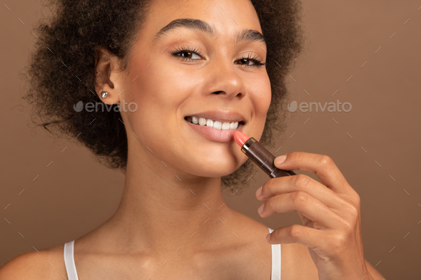 Glad Cheerful Millennial Multiethnic Woman With Nude Makeup Apply Pink