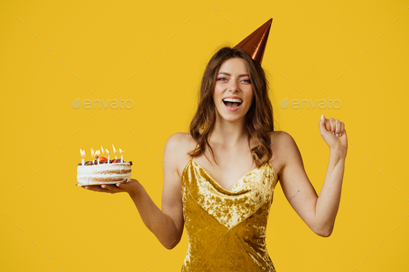 Girl in beige dress and flower crown posing with birthday cake in the  studio Stock Photo | Adobe Stock