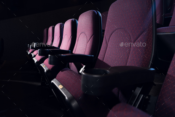row of red seats in empty dark cinema