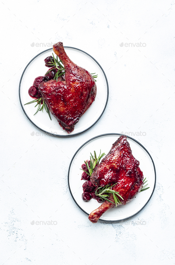 Baked duck legs in cherry red wine sauce with rosemary. Delicacy dinner