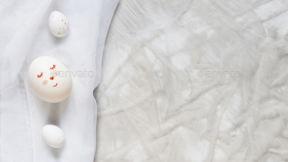 Minimalism, eggs with a hike and chocolate candy eggs on a white fabric on a light gray background. - Stock Photo - Images