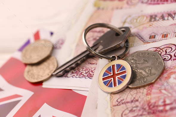 UK money bills and key for house close up. Big amount of United Kingdom pounds