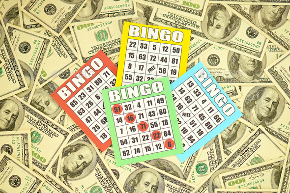 Many bingo boards or playing cards for winning chips and big amount of dollar bills - Stock Photo - Images