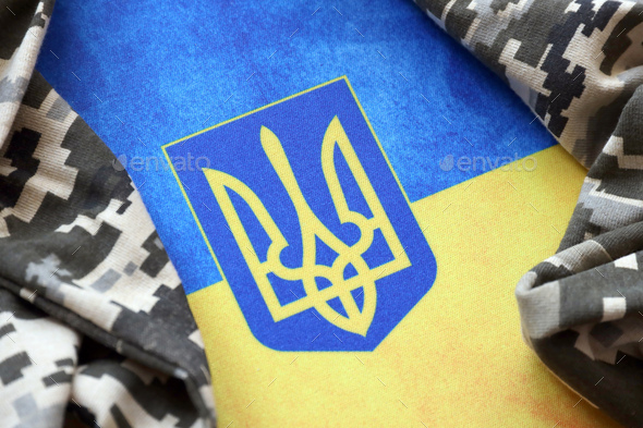 Ukrainian flag and coat of arms with fabric with texture of pixeled camouflage - Stock Photo - Images