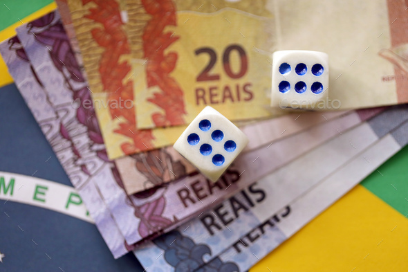 Dice cubes with brazilian money bills on flag of Brasil Republic - Stock Photo - Images