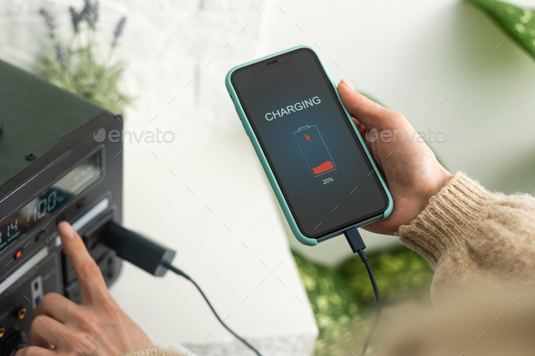 Charging mobile phone battery with wireless charging device in the table. Smartphone charging on a