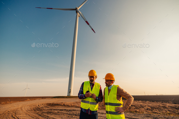 Wind Turbine middle age mechanical engineers working outdoors