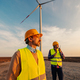 Engineers standing in field with wind turbines - PhotoDune Item for Sale