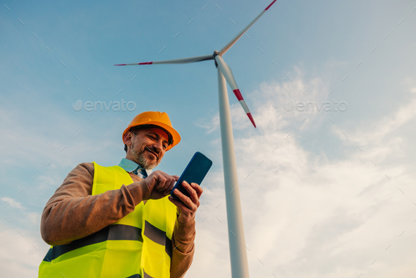 Male engineer using cellphone outdoors - Stock Photo - Images