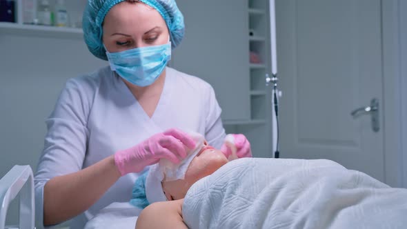 Cosmetologist Performs the Procedure of Cleansing and Moisturizing the Skin