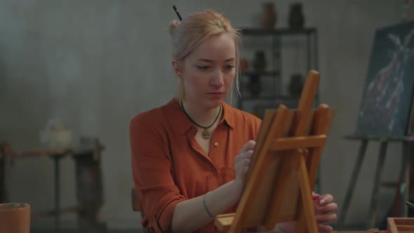 Gifted Woman Painter Creating Oil Painting on Easel alt