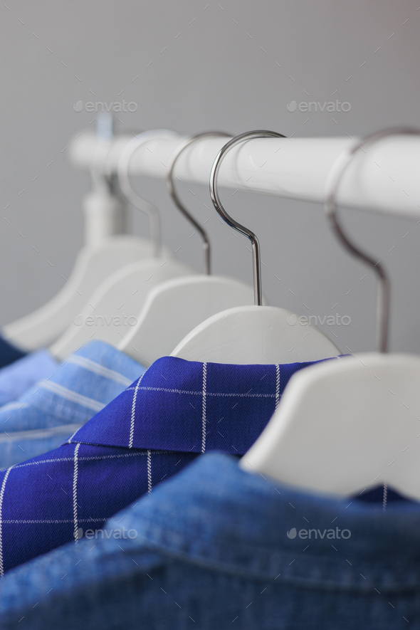 hangers with clothes, wardrobe shirt jacket blue. storing clothes or shopping. Stock Photo by myjuly