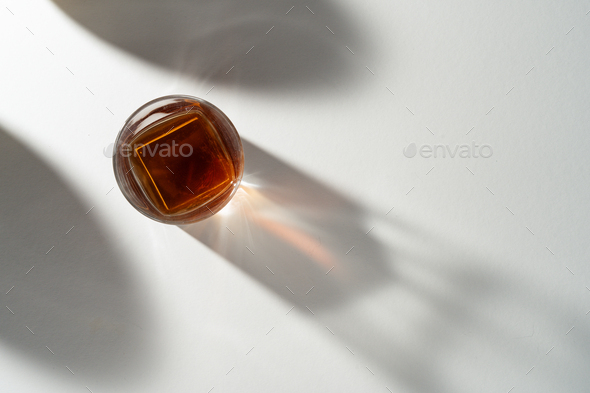 Still life shot of whiskey glass with light and shadows - Stock Photo - Images