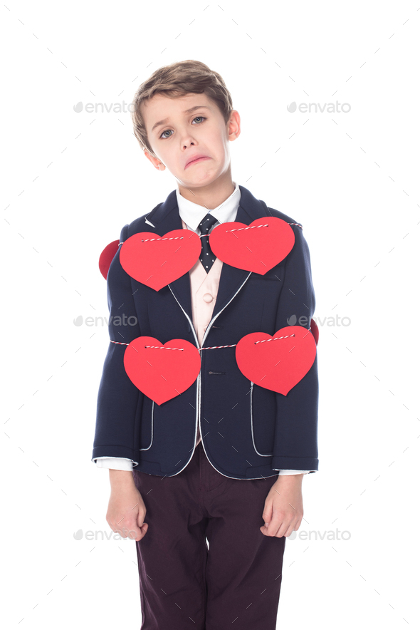 upset little boy in suit staying tied with rope and red hearts, looking at  camera isolated on white Stock Photo by LightFieldStudios
