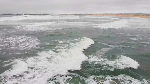 Aerial View of Sea Waves Break on Yellow Sand Beach