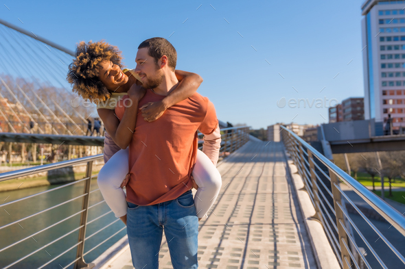 Multiracial couple on city street, lifestyle, smiling man with ...