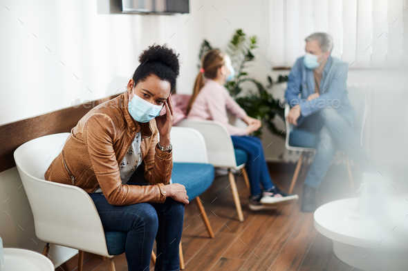 Pensive black woman wearing face mask while waiting for dental appointment at dentist\'s office.