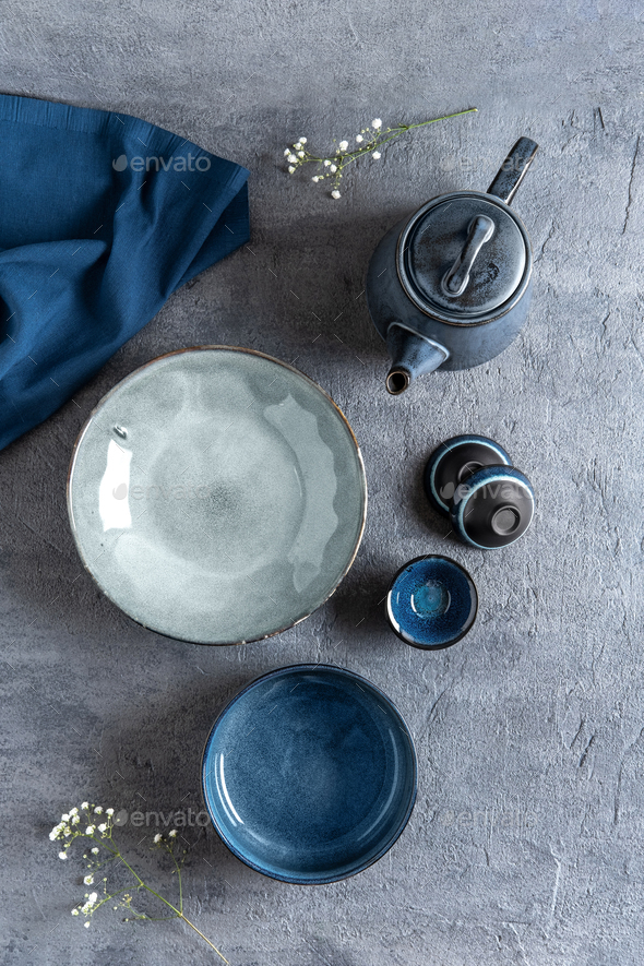 Modern still life with a set of blue crockery.Blue ceramic tableware crockery set on a stone