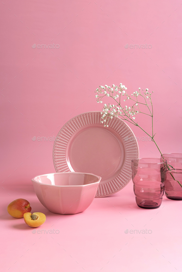 Modern still life with a set of pink crockery.Pink ceramic tableware crockery set on pink background