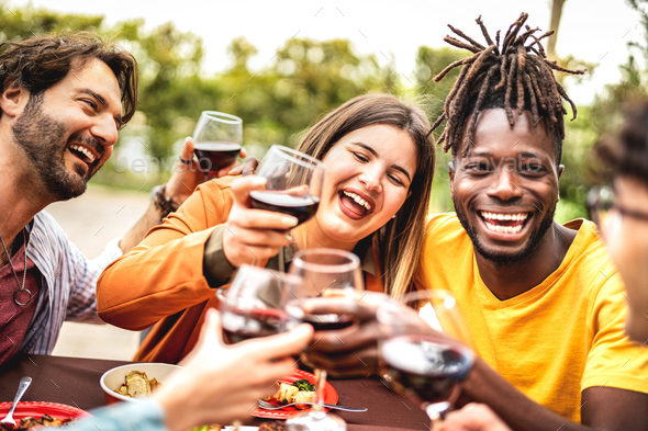 Mixed age range people on genuine mood drinking red wine at pic nic party