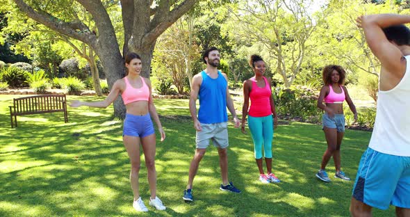 Group of friends exercising in park alt