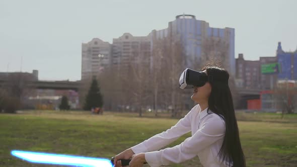 Modern Playing in Virtual Reality Glasses with Laser Lightsaber Swords Outdoors alt