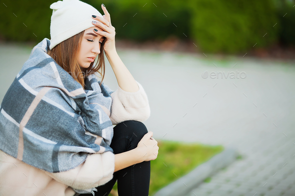 Sick woman on the street suffers symptoms of a cold virus