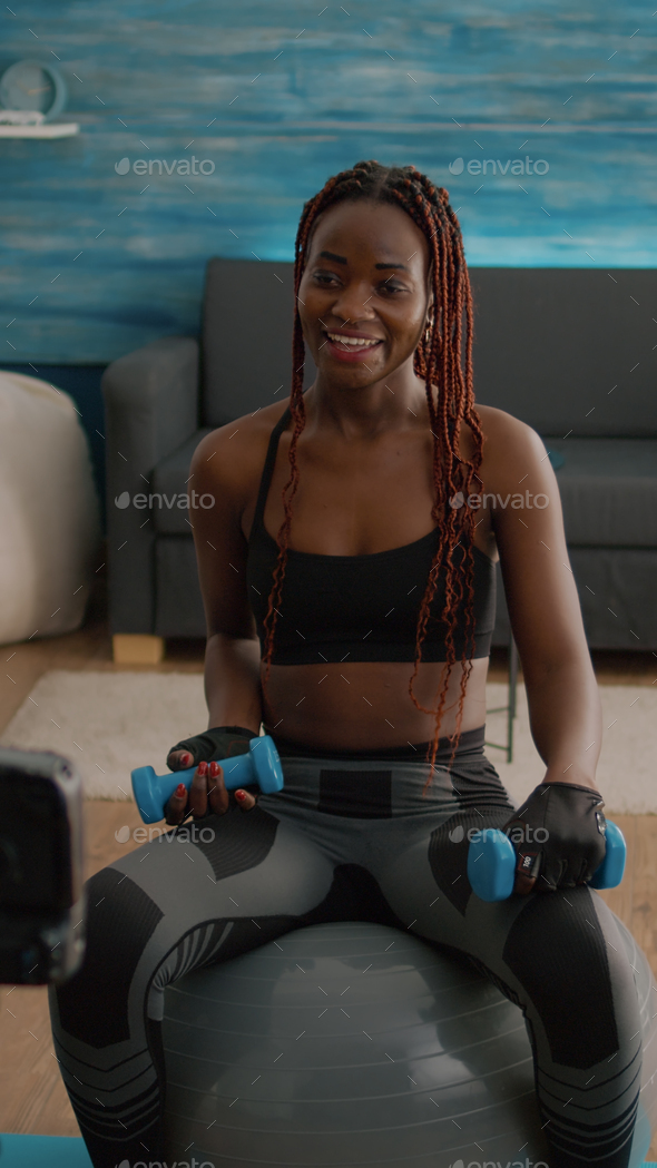 Athletic black woman doing morning fitness workout in living room Stock  Photo by DC_Studio