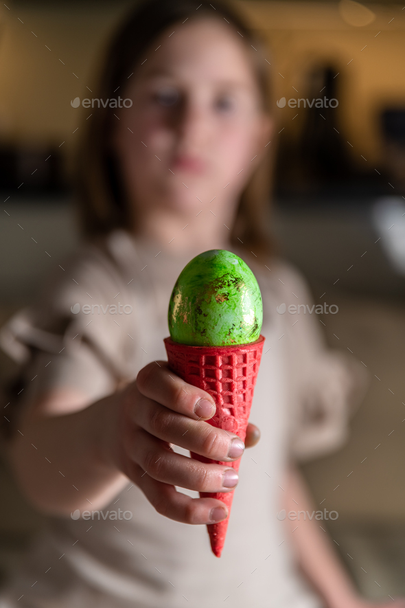 girl holding an Easter egg in a colored ice cream cone Stock Photo by iloli