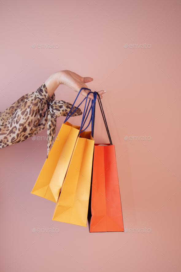 a girl holds shopping bags on a colored background - Stock Photo - Images